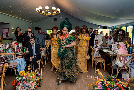 Igbo bride entering with her bridesmaids for the traditional ceremony at Kinmount House during their Nigerian wedding in Scotland.