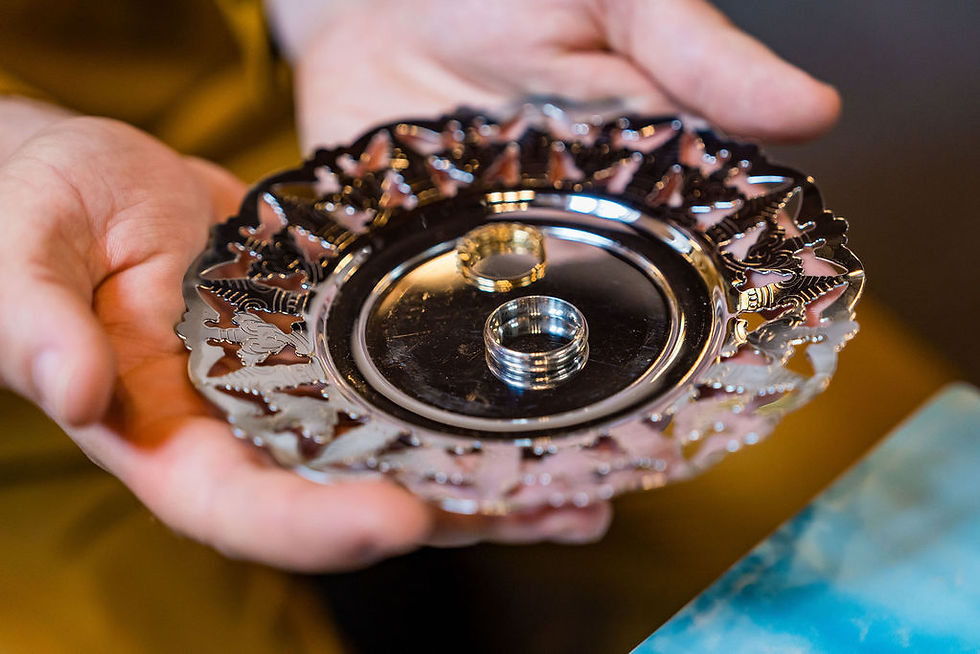 A close up shot of the wedding rings, capturing at the soft light of the church.
