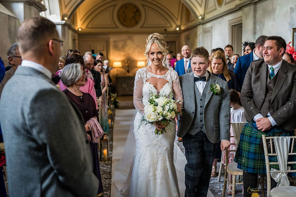 Bride walking down the aisle with her son during emotional ceremony at Balbirnie House wedding in Scotland