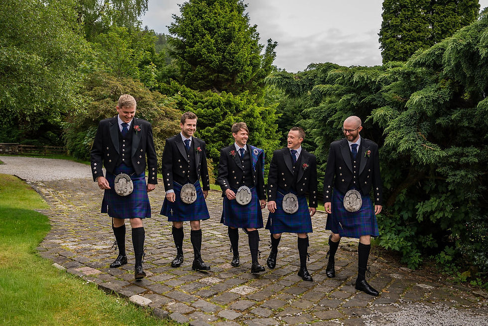 Groom and groomsmen walking together before outdoor wedding ceremony at Venachar Lochside
