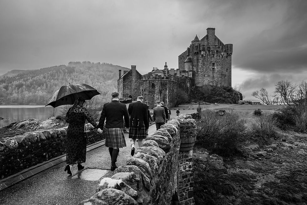 Guests arriving at Eilean Donan Castle for a Scottish Highlands wedding.
