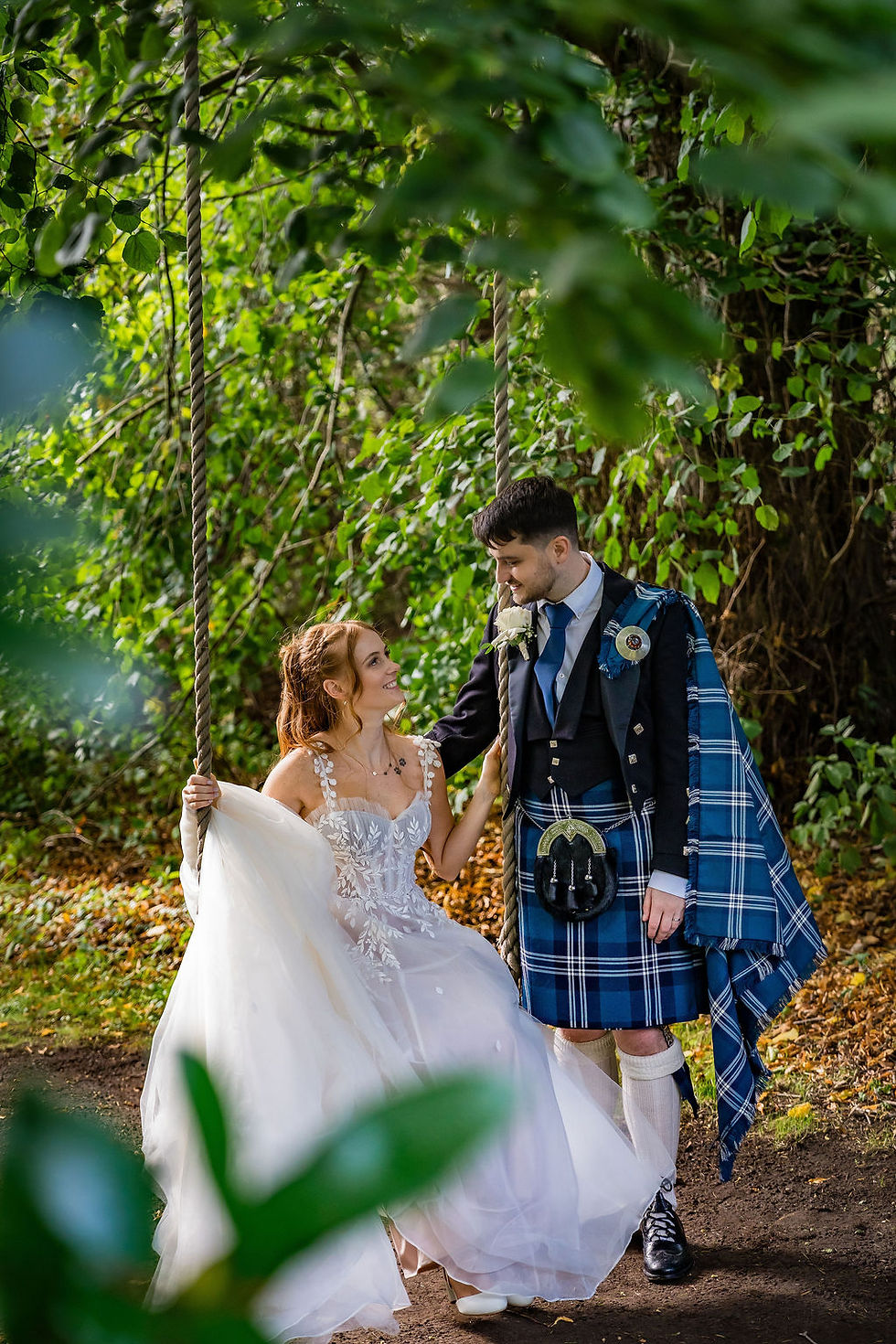 Romantic wedding portrait of the bride and groom sitting on a garden swing at Balbirnie House in Fife, captured naturally by a documentary wedding photographer.