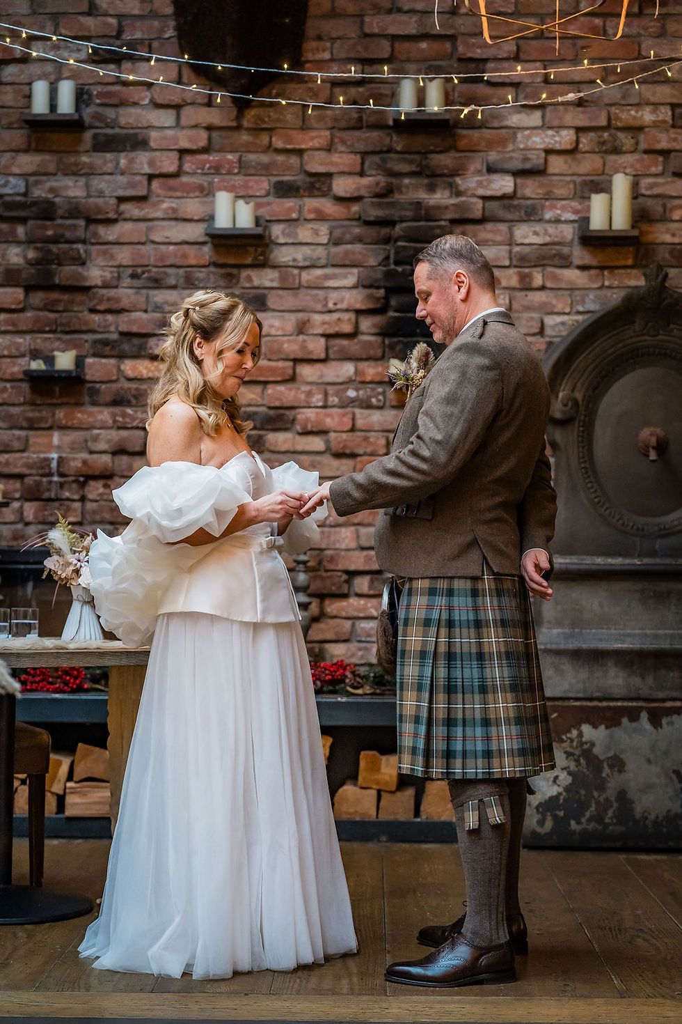 Bride and groom exchanging rings during their indoor ceremony at Forgan’s Broughty Ferry.