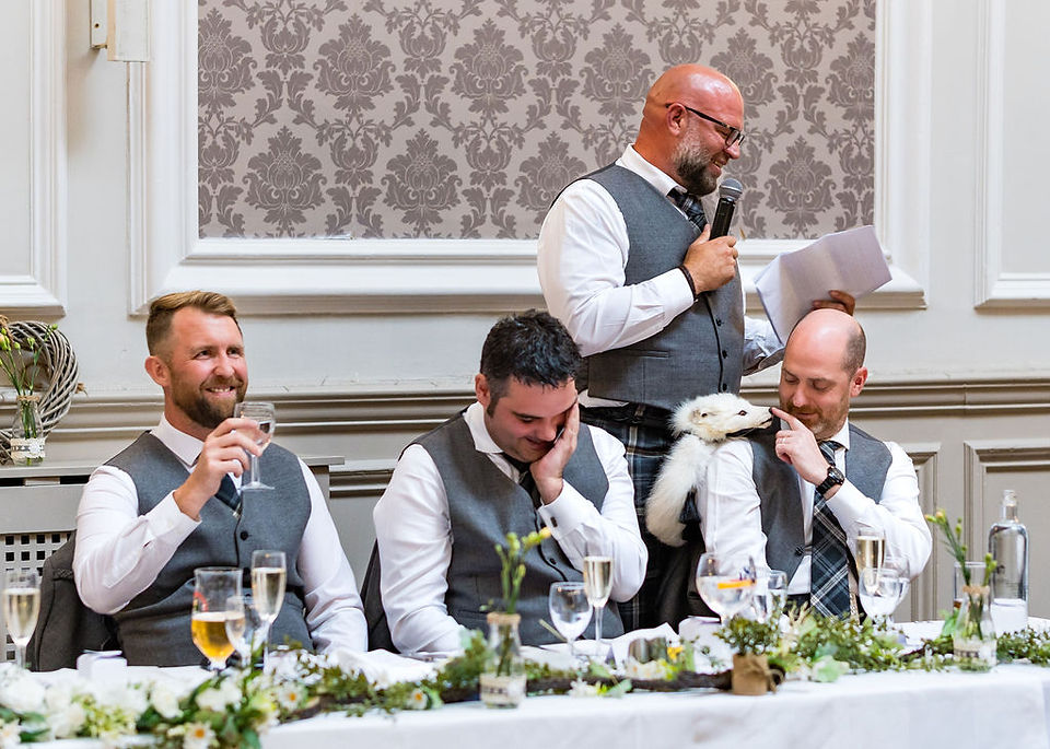 Groomsmen burst into laughter as the groom delivers his speech at Peebles Hydro wedding reception—candid and joyful Scottish wedding photography.