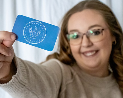 Hampton Roads Doula Kayla Wamsley holds up her business card