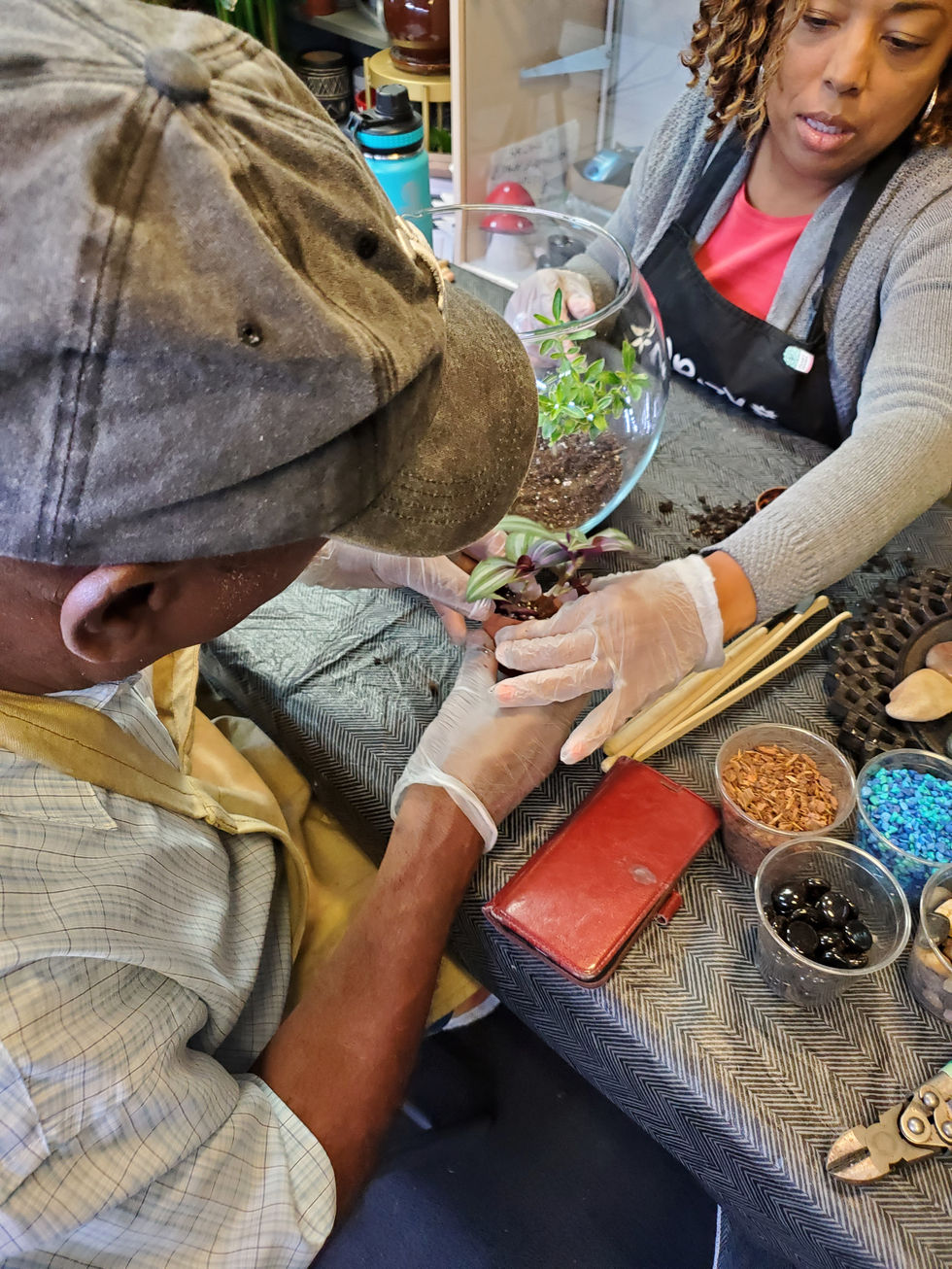 Image of a couple working together collectively to design a terrarium at Unique Arrangements: Couple's Night Out