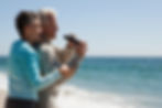 mature-couple-at-the-beach-with-binoculars-C West Realty