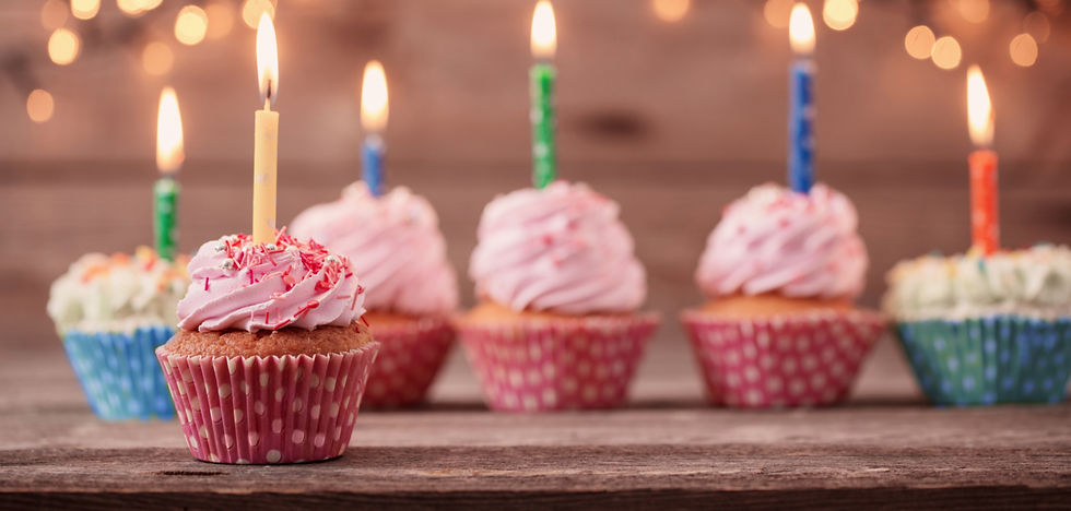 Frosted cupcakes with lit candles