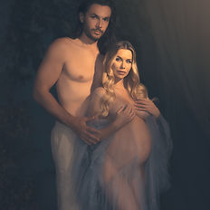 Sensual and artistic portrait of a pregnant woman with her partner, captured in soft shadow lighting. Emotional, powerful, and intimate representation of motherhood and union.