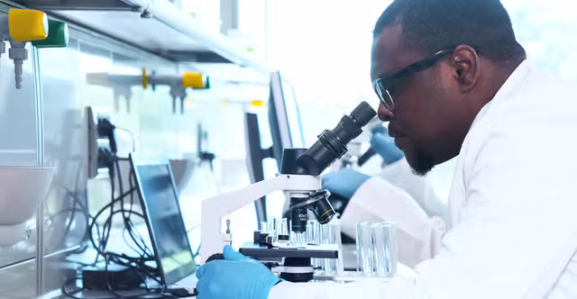 Scientist in a labcoat analyzing a specimen