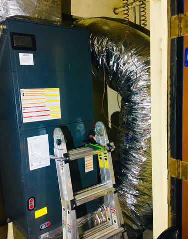 HVAC furnace unit, silver ductwork and a ladder