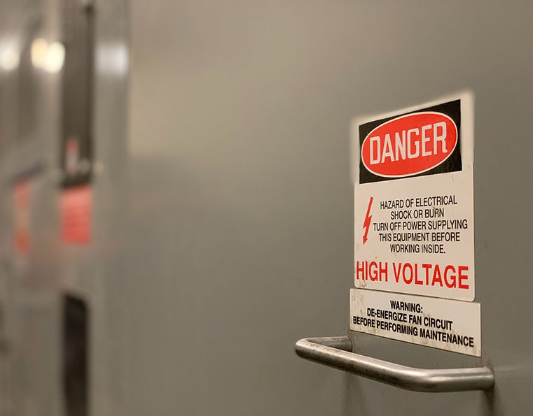 an industrial electrical room with a high voltage sign on the door