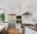an all white spotless kitchen with stainless appliances and recessed lighting