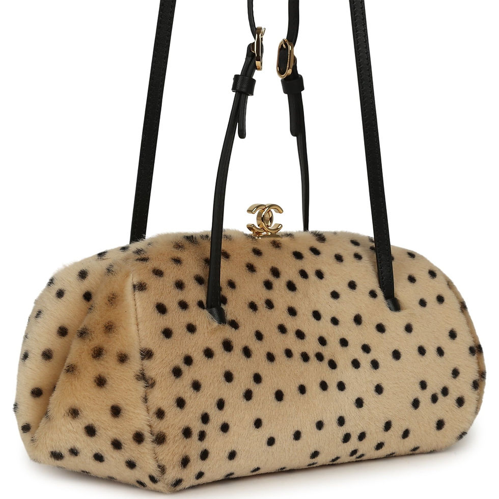 Angled view of the calf hair clutch with black leather straps and gold-tone frame