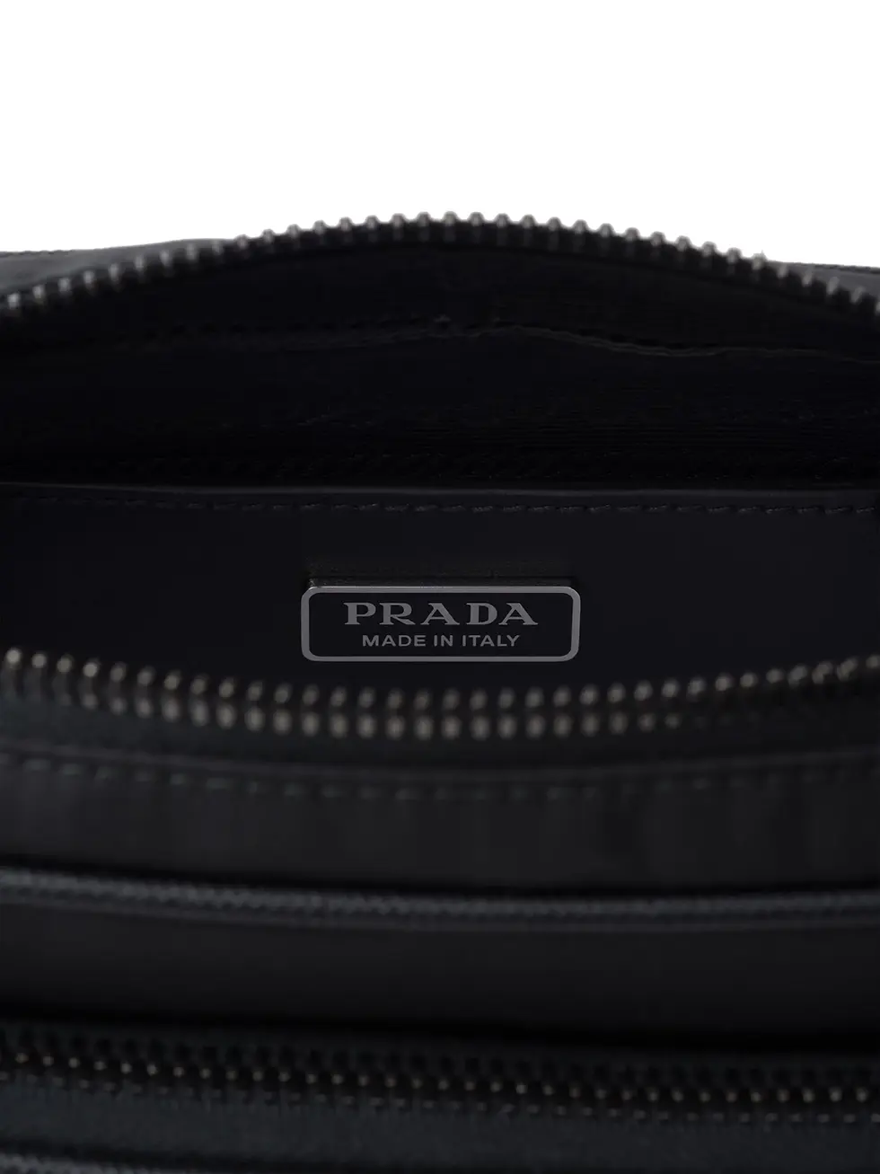 Thumbnail: Back of the black Prada Saffiano bag with embossed PRADA lettering