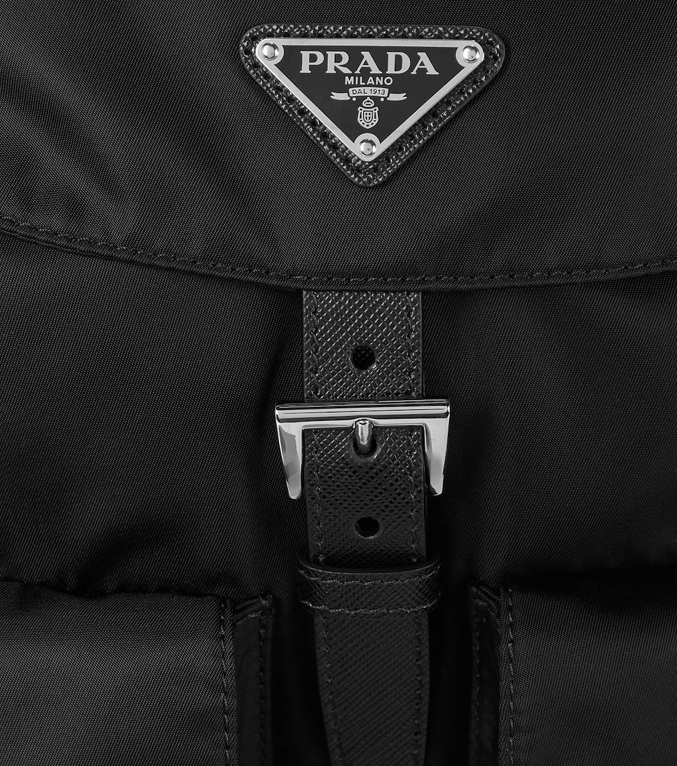 Thumbnail: Close-up of the enamelled Prada triangle logo plaque on the front