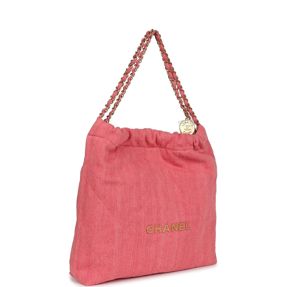 Angled front-side view of the coral-pink denim bag showing the gold-tone chain strap