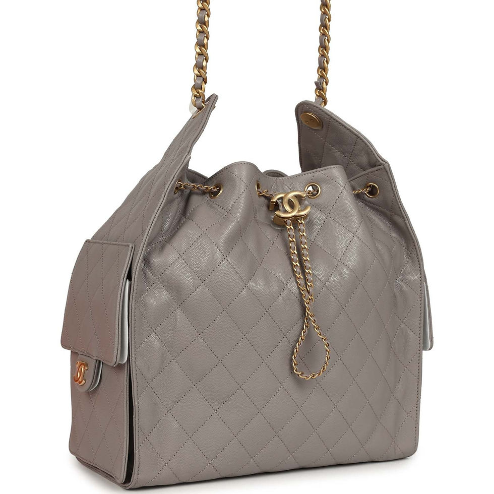 Angled front view of the grey quilted hobo showing chain drawstring and side pocket
