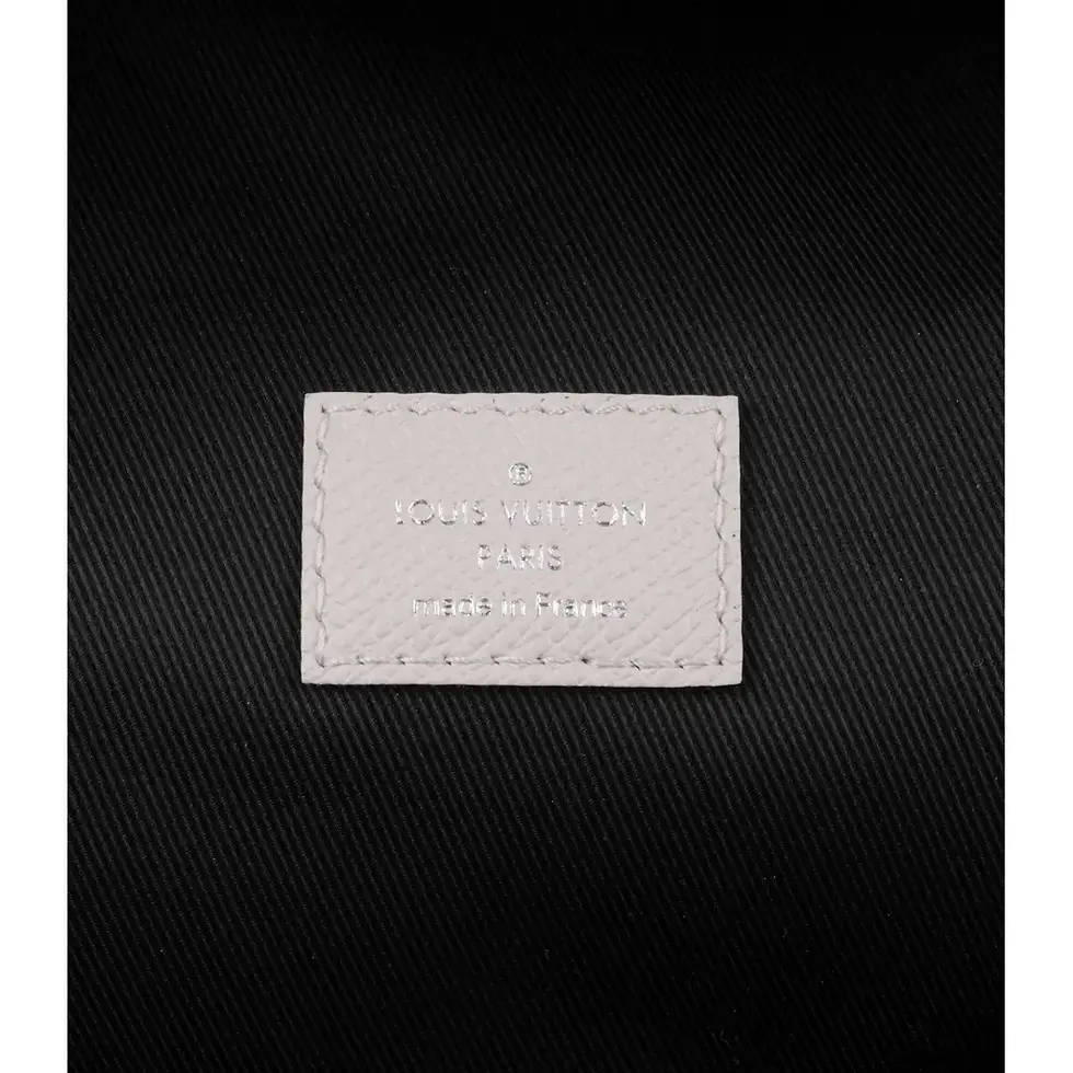 Thumbnail: Close-up of the embossed Louis Vuitton leather label on the backpack