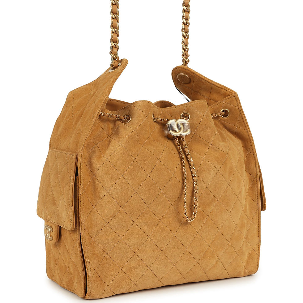 Angled front view of the quilted beige suede bag showing its chain drawstring