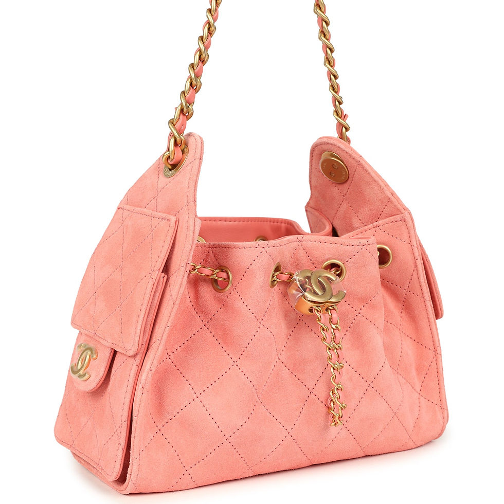 Three-quarter view of the coral pink suede hobo bag showing the quilted side flap pocket
