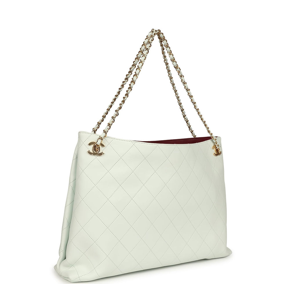 Three-quarter view of the tote showing the chain-and-leather strap and quilted stitching