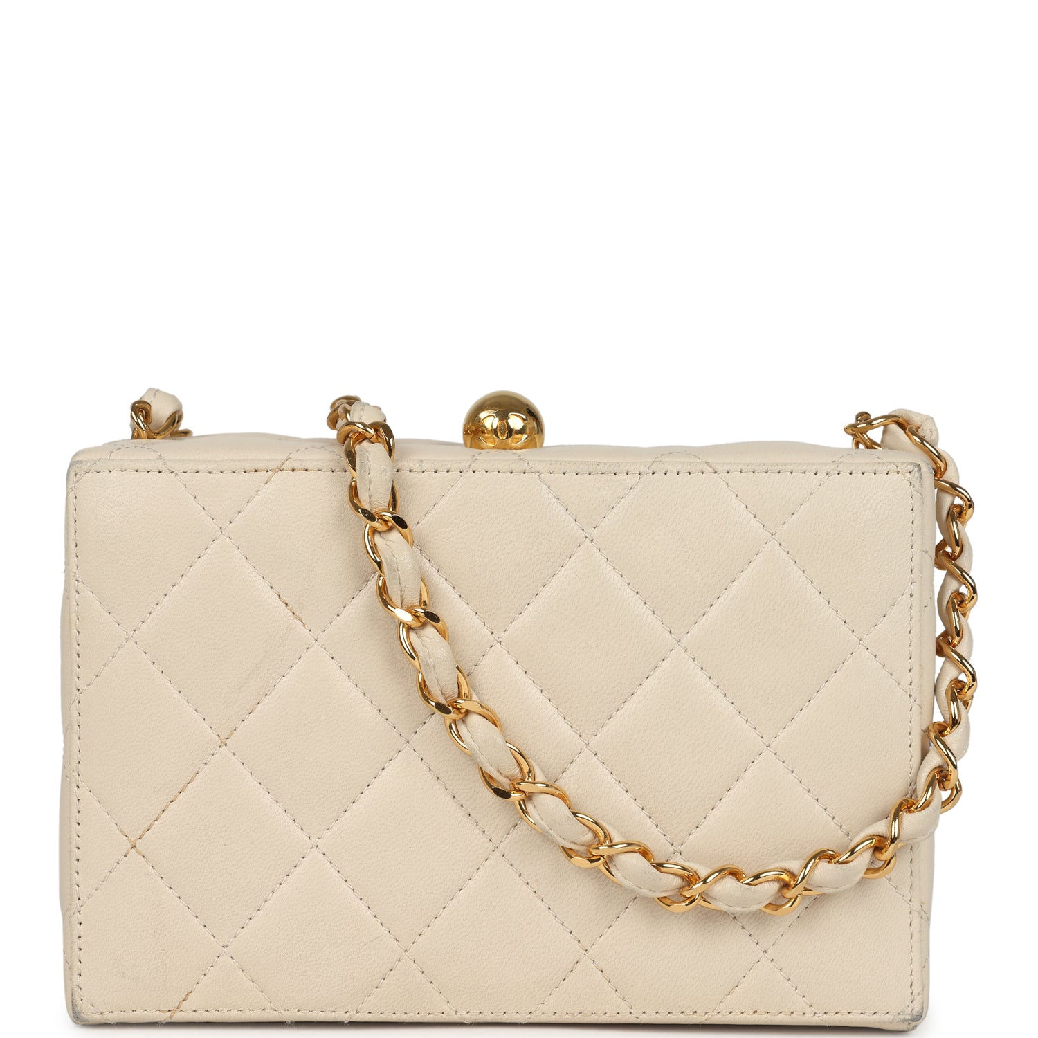 Front view of a vintage beige quilted lambskin Chanel box clutch with gold ball clasp