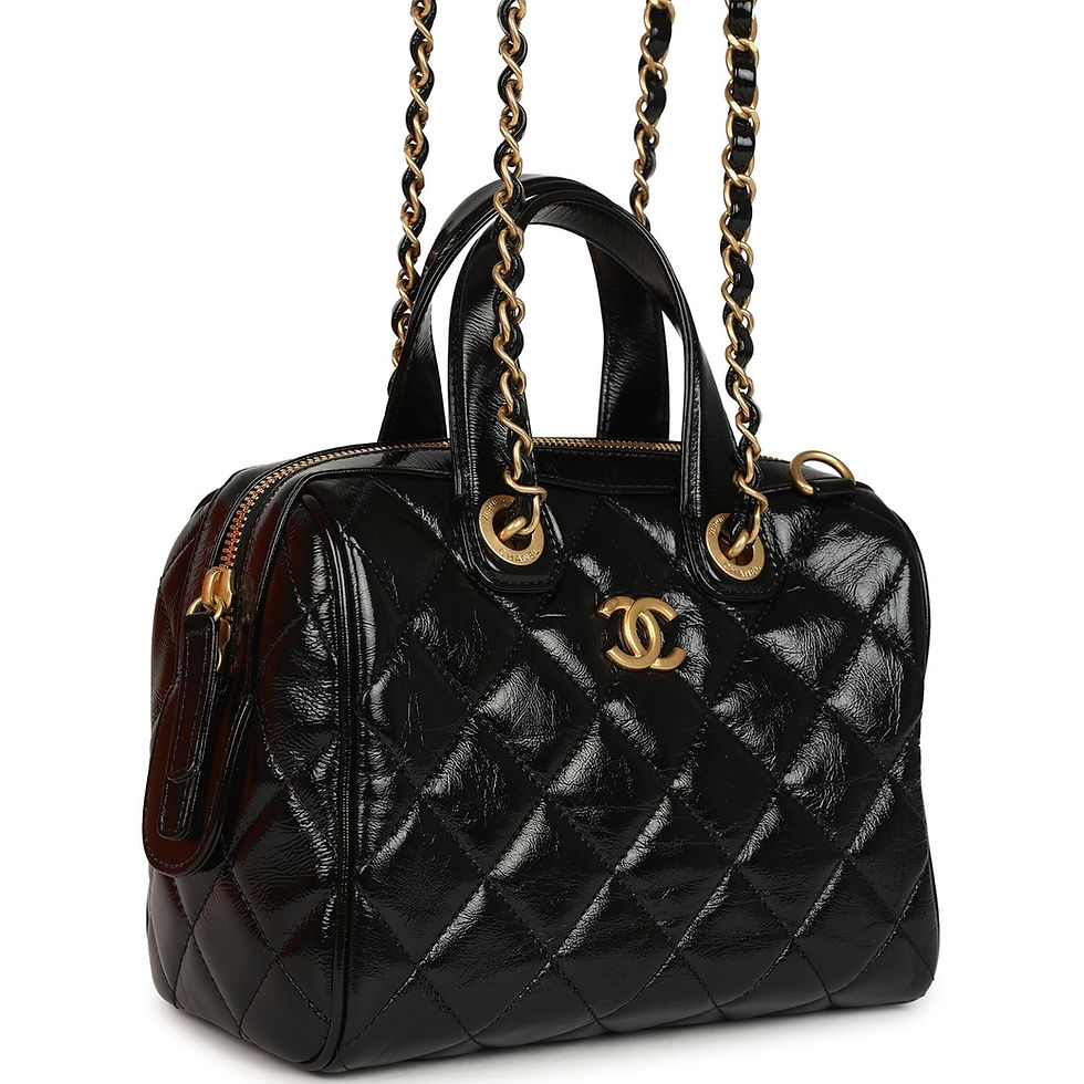 Side-angle view showing the bag's rolled top handles and chain-and-leather strap