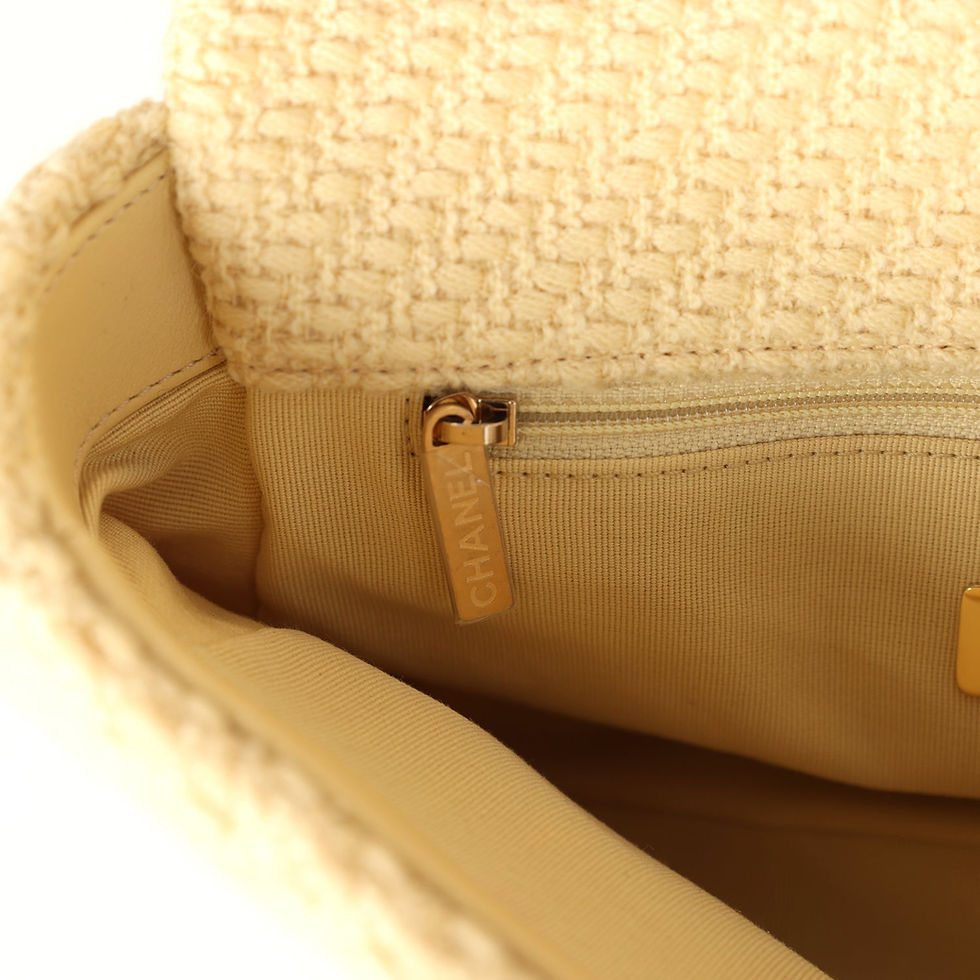 Thumbnail: Interior zip pull with engraved Chanel tag against the beige fabric lining