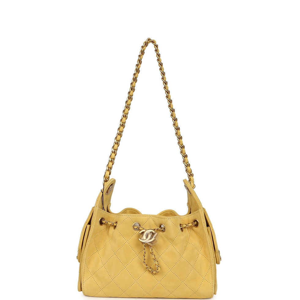 Thumbnail: Angled front view of the mustard yellow suede hobo bag with both quilted side pockets