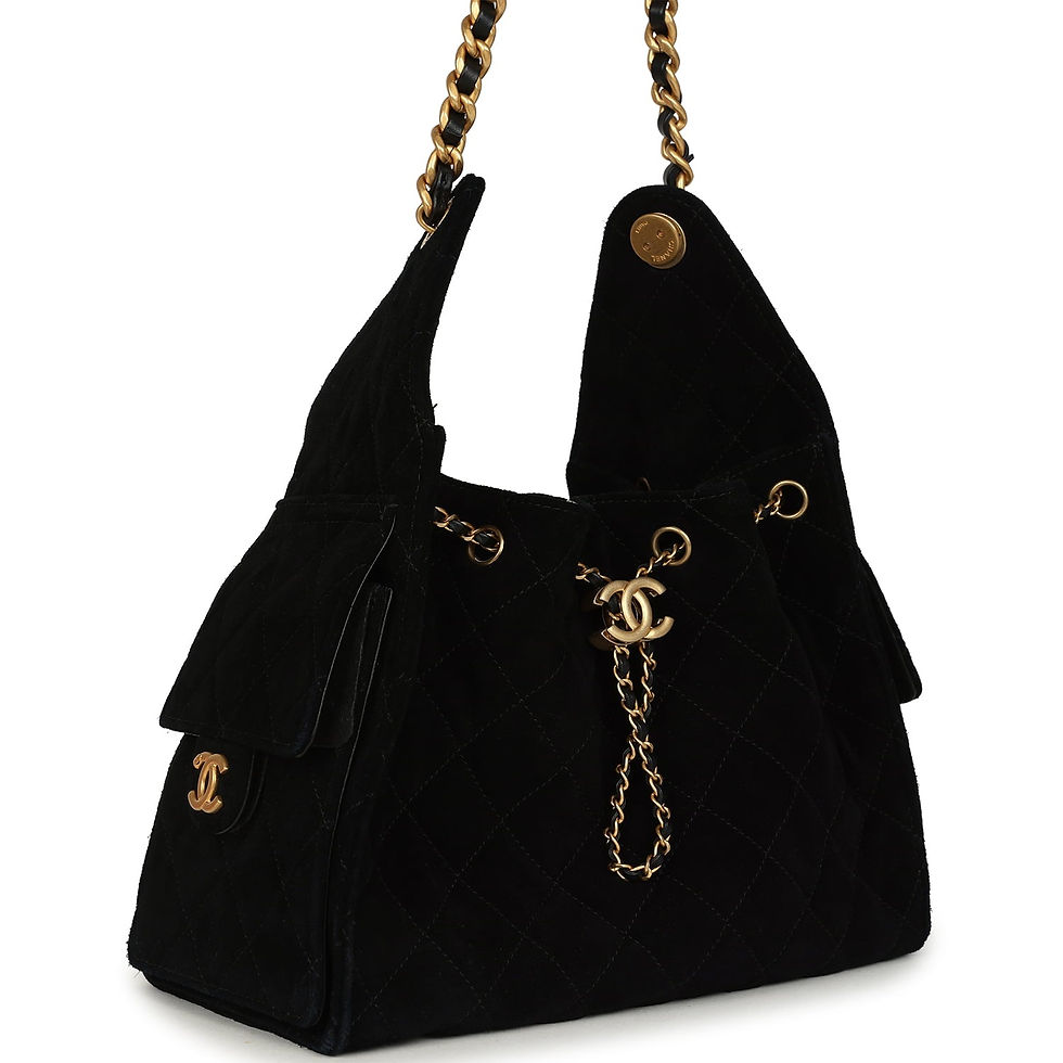 Three-quarter view of the black suede hobo bag showing the side flap pocket and chain strap