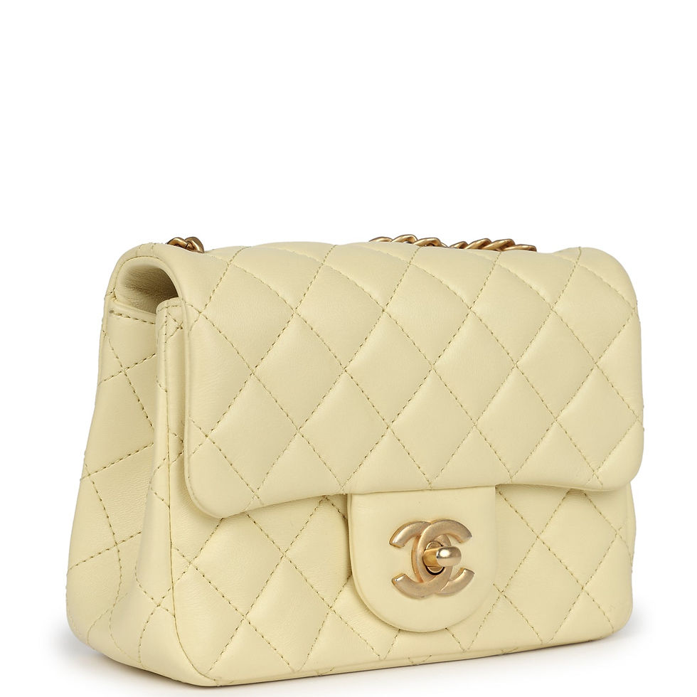 Three-quarter view of the yellow square flap bag showing the camellia charm on the chain
