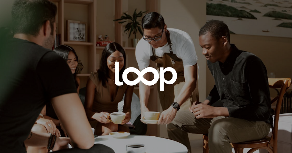 Group of people sitting around table, having a cup of coffee, with Loop (Loneliness Awareness Week partner) Logo in middle