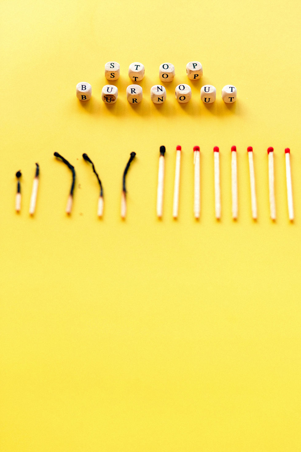A line of new and used matches, with a line of alphabet blocks above that read "STOP BURNOUT"