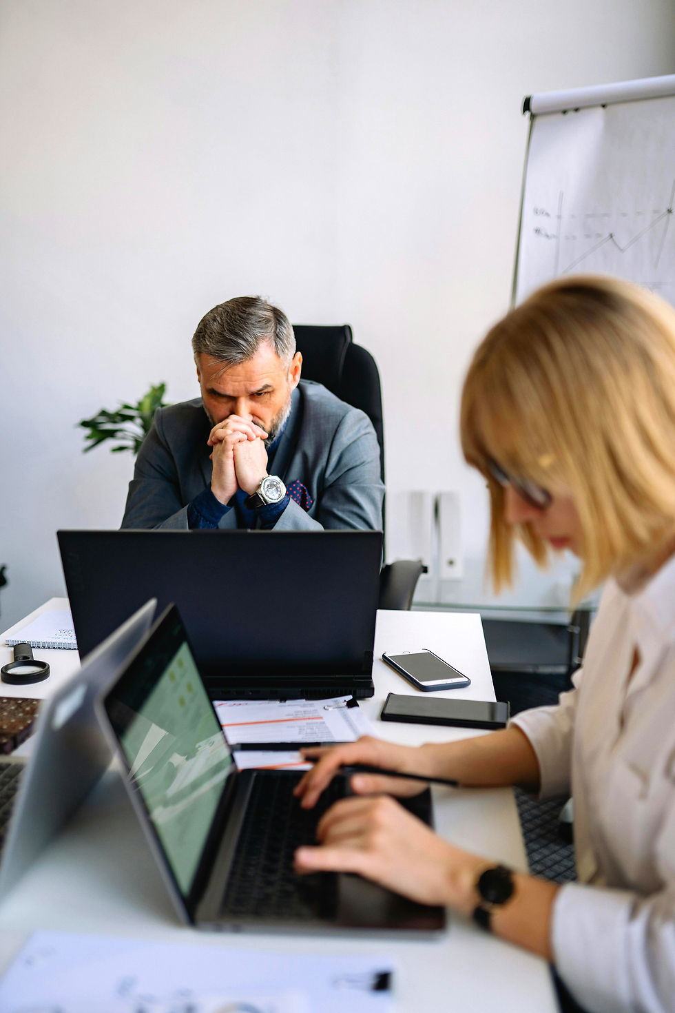 Stressed man and woman working on laptop