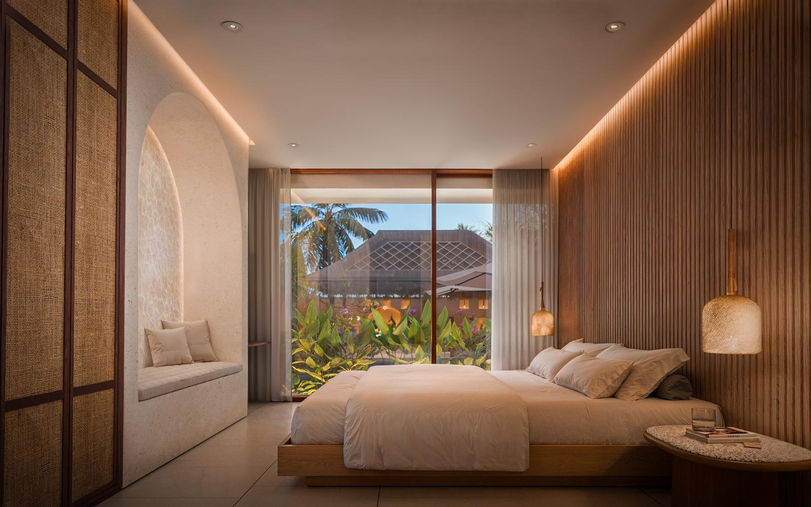 Luxury master bedroom with warm lighting and pool view in Serangan Lombok.