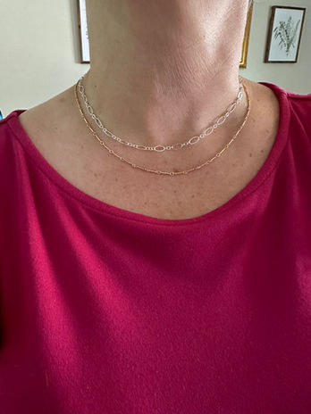 A woman's neck is adorned with two permanent necklaces
