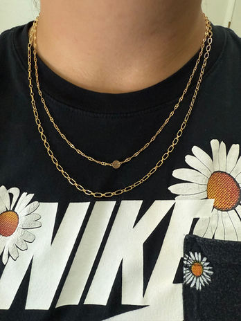 A woman's neck is adorned with two permanent necklaces