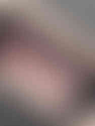 A tattoo of a close-up  animated character in black and grey with blood splatter on their face.