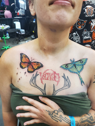 Two fresh color tattoos of a butterfly and a moth on each collarbone.