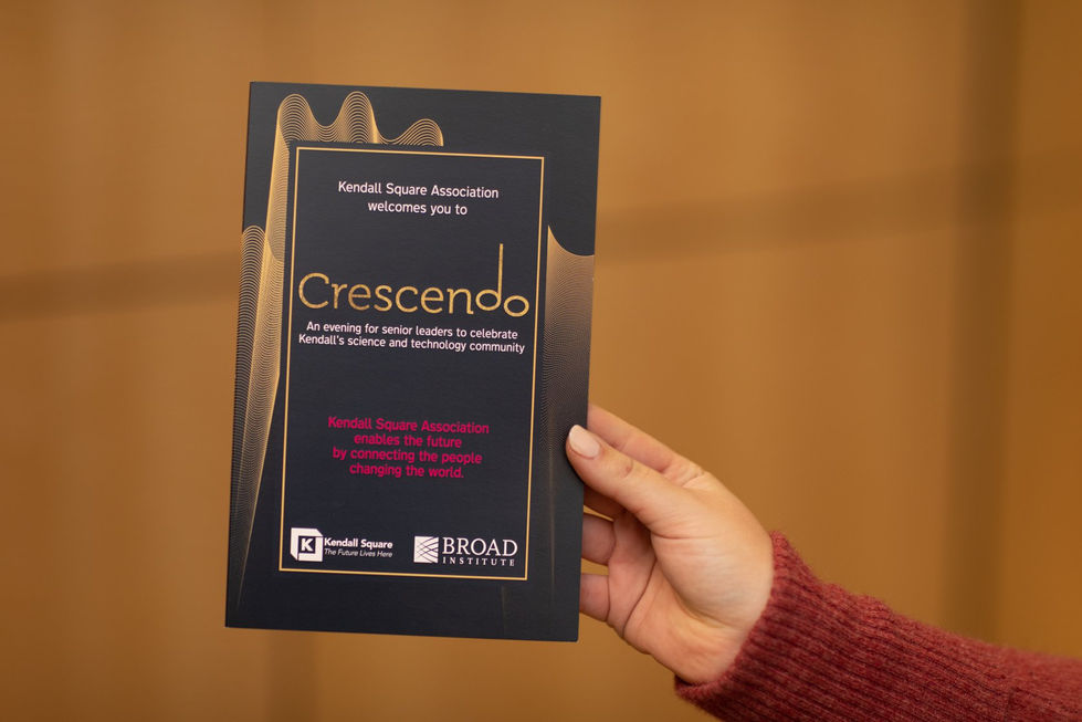 Hand holding a printed Crescendo program featuring gold details and event info.