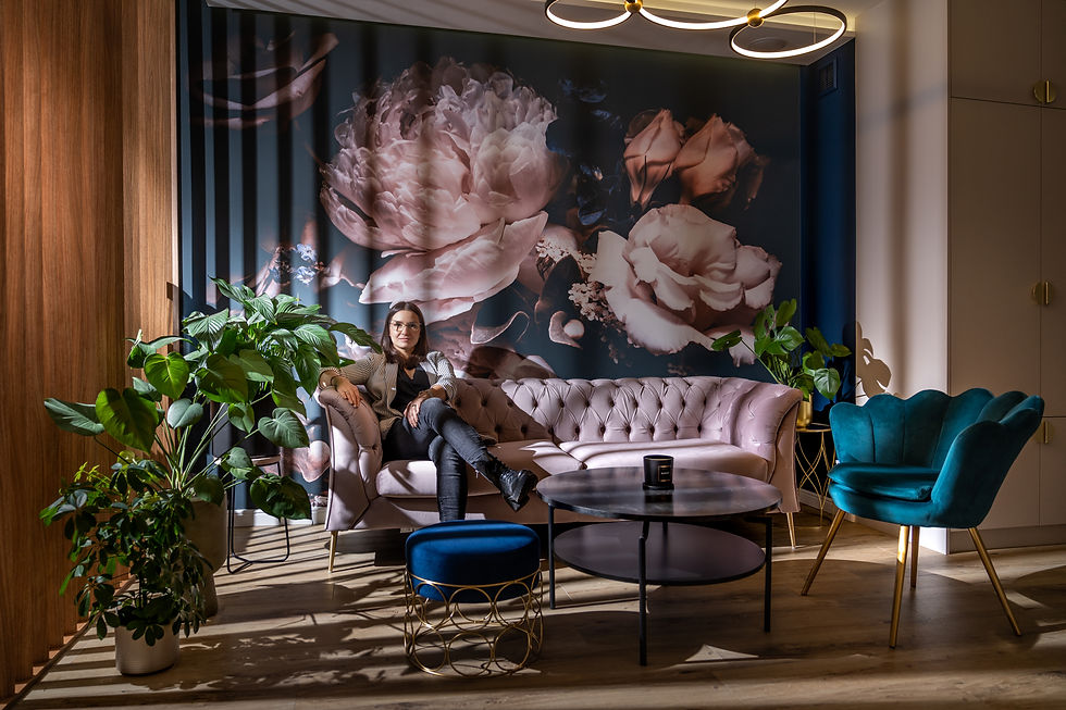 Elegancki salon poradni z różową sofą i kwiatowym akcentem.
