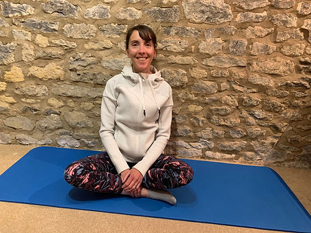 Pilates instructor sitting on mat