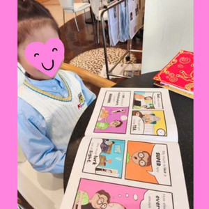 Little girl reading My Mummy is a Super Mum