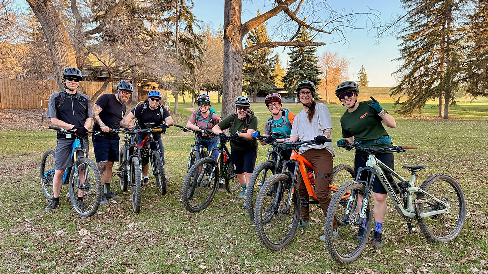 A group of riders posing with their bikes looking stoked.