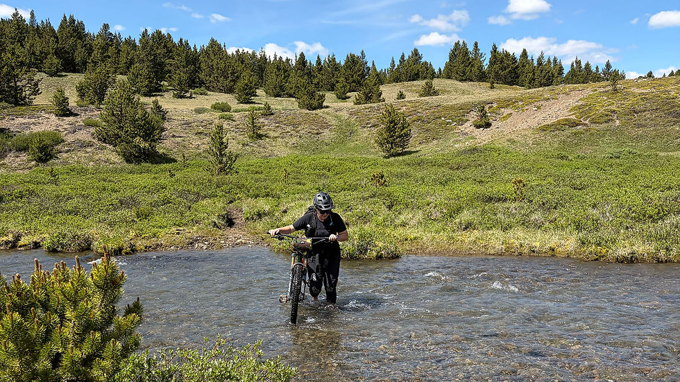 Katie crossing the river with her mountain bike