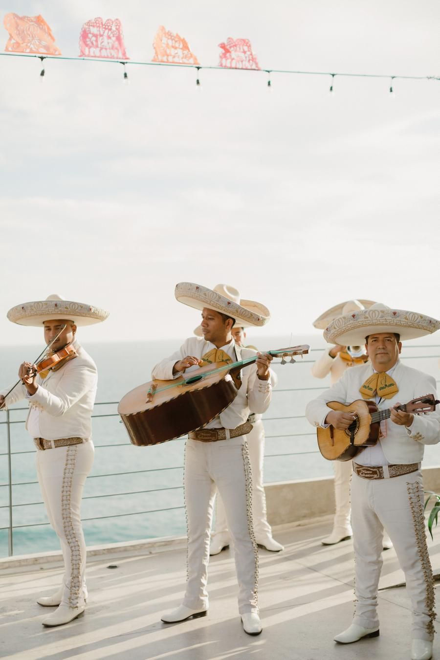 Eye-level view of mariachi band playing on a beach at sunset in Cabo San Lucas