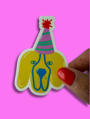 Colorful Great Dane party hat sticker held in hand against pink background.