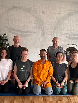 Group photo of yoga class, diverse individuals smiling together. Tree Of India Yoga.