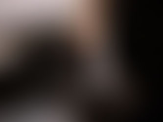 Photographer picking up camera from table surround by photography gear and natural light